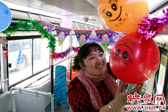 鄭州快速公交B3區(qū)間線車長李鵬云在車廂里懸掛氣球，布置圣誕車廂，營造歡樂圣誕氛圍