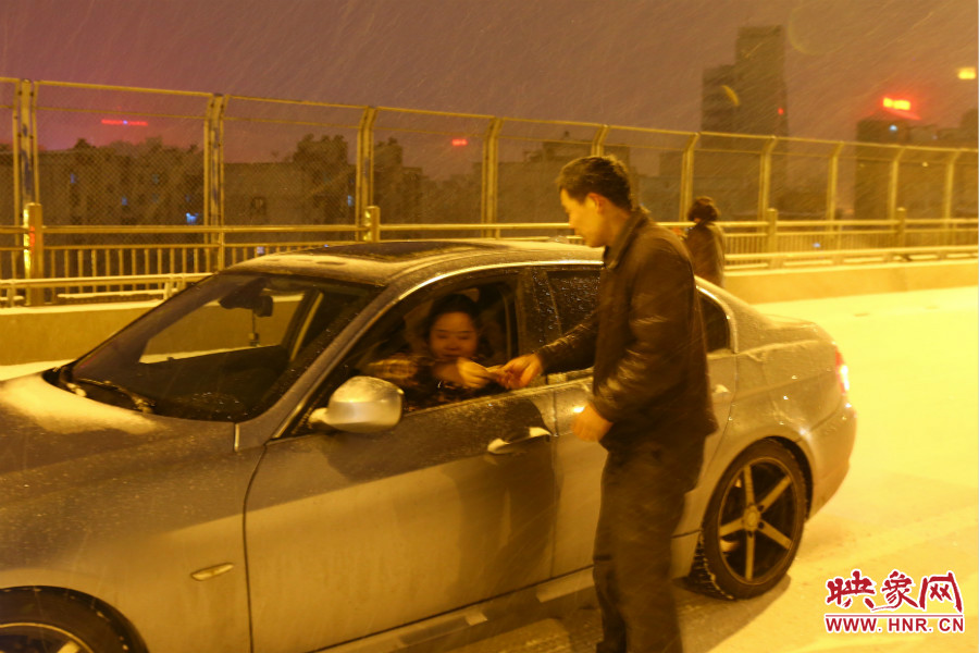 “推車人”幫助一輛車上坡后，收取“勞務(wù)費(fèi)”。