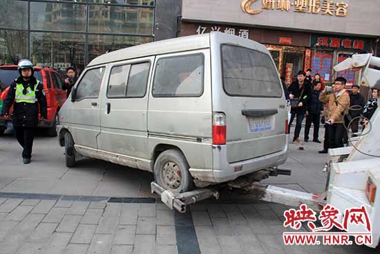 一輛長(zhǎng)期占用人行道的車輛被拖走