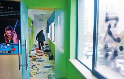 　健身會所地上一片狼藉，玻璃上噴著黑色“欠錢”二字。