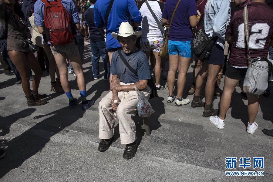 一名男子坐在參加不穿褲子搭地鐵的人群邊小憩。