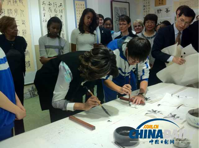 　北京時間3月21日，美國第一夫人米歇爾參觀北師大二附中時，與學生一起練習書法。