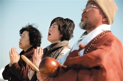 23日，一名僧侶引領(lǐng)人們?yōu)樗勒咂矶\。