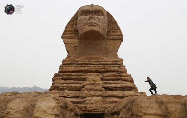 石家莊郊外，一名男子與山寨版獅身人面像合影留念。