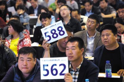 昨日，拍賣現(xiàn)場競拍者舉牌競拍。新京報(bào)記者