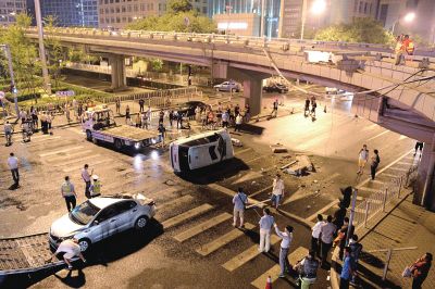 路虎沖下國貿(mào)橋砸中一輛起亞轎車，橋上厚達(dá)幾十厘米的水泥護(hù)欄被撞斷，碎石四處散落，數(shù)十群眾在現(xiàn)場圍觀。