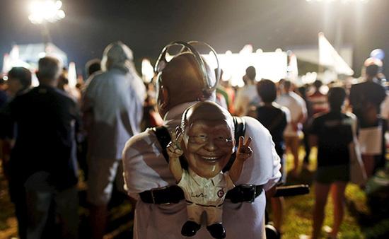 9月4日，新加坡，執(zhí)政黨的一場集會上，一名支持者背著一個李光耀的人偶。