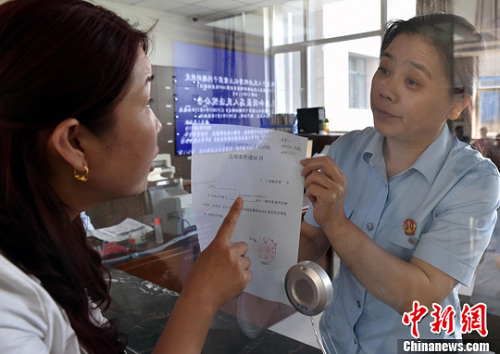 資料圖：2015年5月4日，河北石家莊市橋西區(qū)人民法院立案庭庭長(zhǎng)齊燕正在為立案人辦理相關(guān)手續(xù)，完成整個(gè)過(guò)程只用了5分鐘。當(dāng)日是立案登記制改革首個(gè)工作日，該院共立案36件，立案率達(dá)到90%。中新社發(fā) 翟羽佳 攝