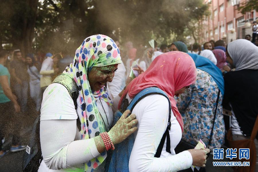10月16日，在埃及首都開羅，兩名女青年在“彩色跑”活動(dòng)中躲避人們拋撒的彩色粉末。
