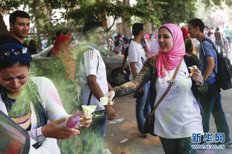 10月16日，在埃及首都開羅，一名女青年在“彩色跑”活動(dòng)中拋撒彩色粉末。