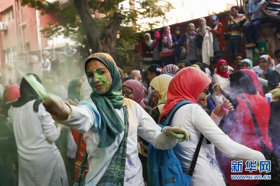 10月16日，在埃及首都開羅，一名女青年在“彩色跑”活動(dòng)中拋撒彩色粉末。