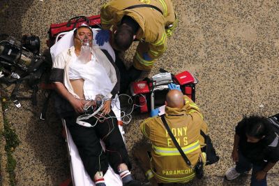 2日，救援人員在美國紐約地鐵事故車輛內(nèi)緊急疏散一名受傷乘客。圖/CFP