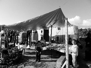 黎巴嫩一敘利亞難民營(yíng)，難民支起攤鋪賣衣服掙錢(qián)。
