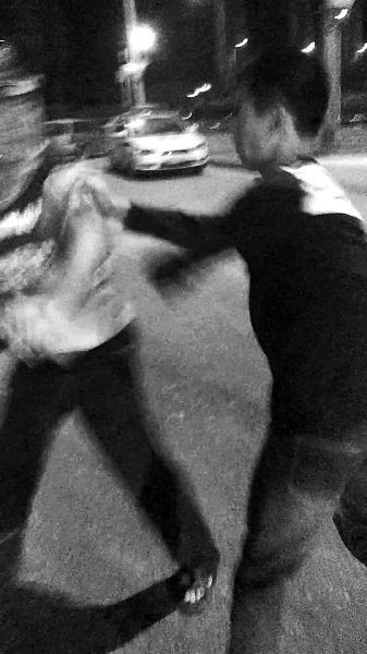 一名男子扯著民警的反光背心一路追打。