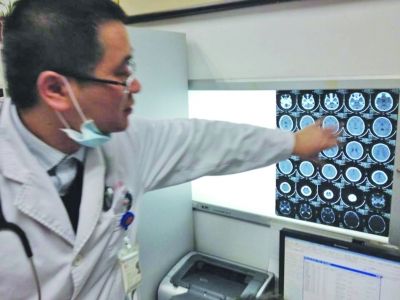 醫(yī)生在查看男孩的腦部CT片。薛馬義 攝