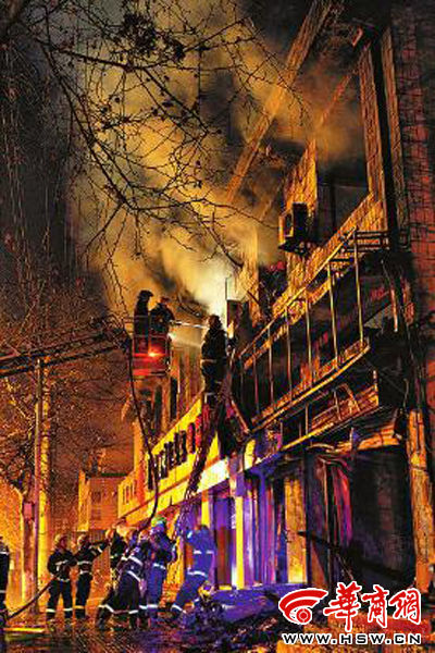 昨日22時(shí)10分，西安市豐慶路南小巷南口，消防官兵架梯子登上二樓施救 本組圖片由本報(bào)記者 閆文青 攝