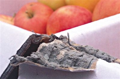 8月29日，新發(fā)地市場，一箱用“加重紙箱”包裝的蘋果正待售，紙箱夾層內(nèi)灰黑色的增重填充物清晰可見