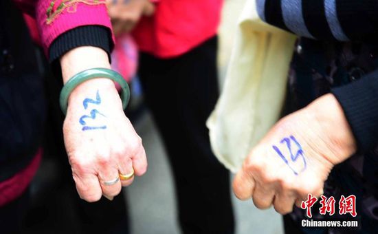 圖為10月28日，在江西九江市一家羊絨皮草服裝服飾博覽會(huì)現(xiàn)場(chǎng)，老人們正在頂著寒風(fēng)排隊(duì)等待領(lǐng)取10元代金劵。