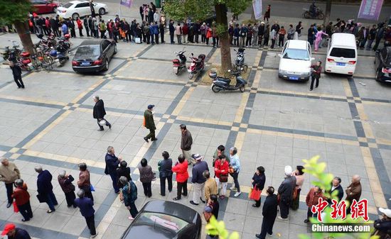 圖為10月28日，在江西九江市一家羊絨皮草服裝服飾博覽會(huì)現(xiàn)場(chǎng)，老人們正在頂著寒風(fēng)排隊(duì)等待領(lǐng)取10元代金劵。