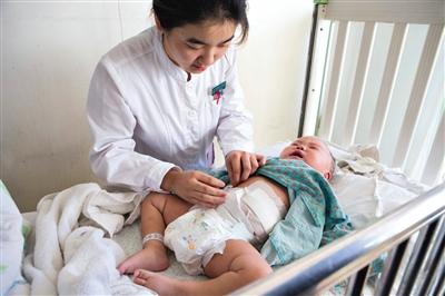 昨日，北京兒童醫(yī)院，護士為即將出院的被扎鋼針女嬰檢查傷口恢復情況。記者 高瑋 攝