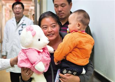 昨日上午，被扎針女嬰的母親抱著孩子和醫(yī)護人員送的玩偶準備出院，院方稱孩子術后恢復良好。記者 高瑋 攝