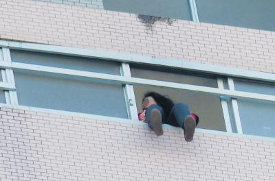 28樓的窗臺(tái)上坐著一名女子，其兩條腿耷拉在室外，不停地?cái)[動(dòng)。