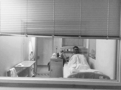 楊杰在醫(yī)院隔離病房中，沖記者揮了揮手。