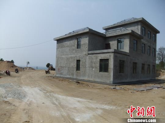 鴨河水庫庫區(qū)邊的新建別墅，一面墻上寫著“拆”，另一邊在加緊施工。吳揚(yáng)　攝